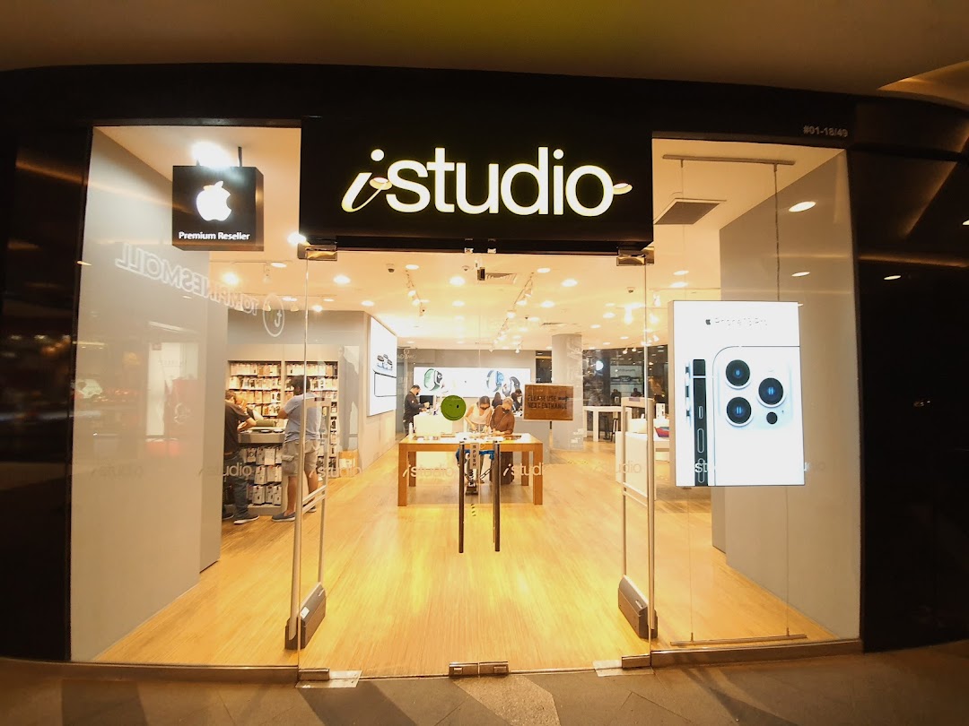 The brightly lit iStudio storefront showcasing Apple products and a 'Premium Reseller' sign.