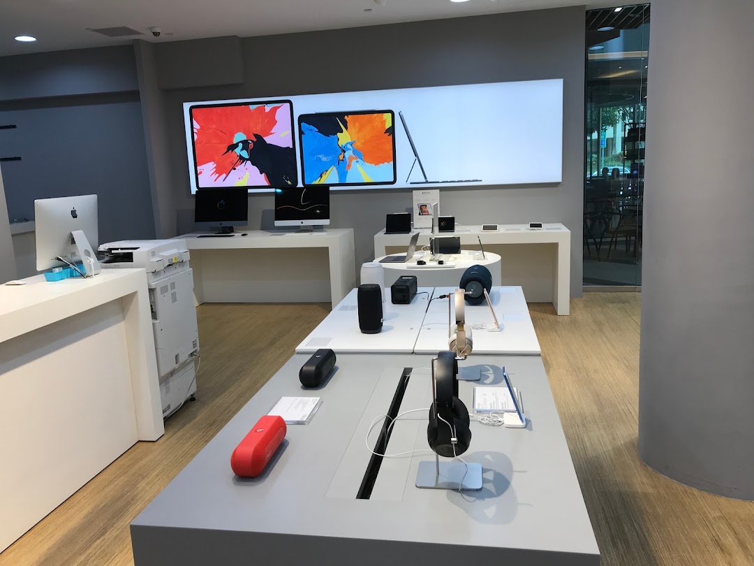 Interior view of iStudio, showcasing Apple products like iMacs, iPads, headphones, and speakers on modern displays.