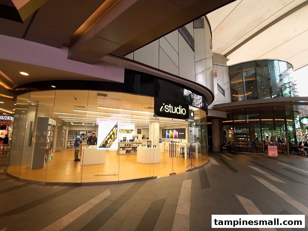 The iStudio shop front at Tampines Mall, showcasing its modern glass exterior and Apple products.