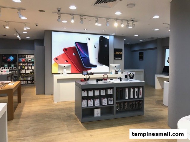 Interior view of iStudio, showcasing Apple products, accessories, and interactive displays in a modern setting.