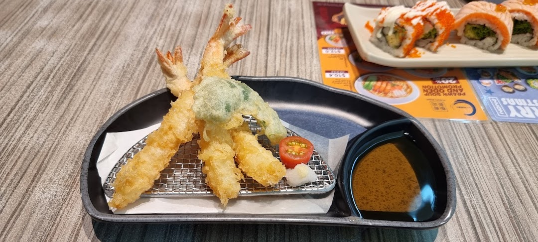 A delicious plate of golden tempura shrimp and vegetable with dipping sauce, alongside sushi rolls.