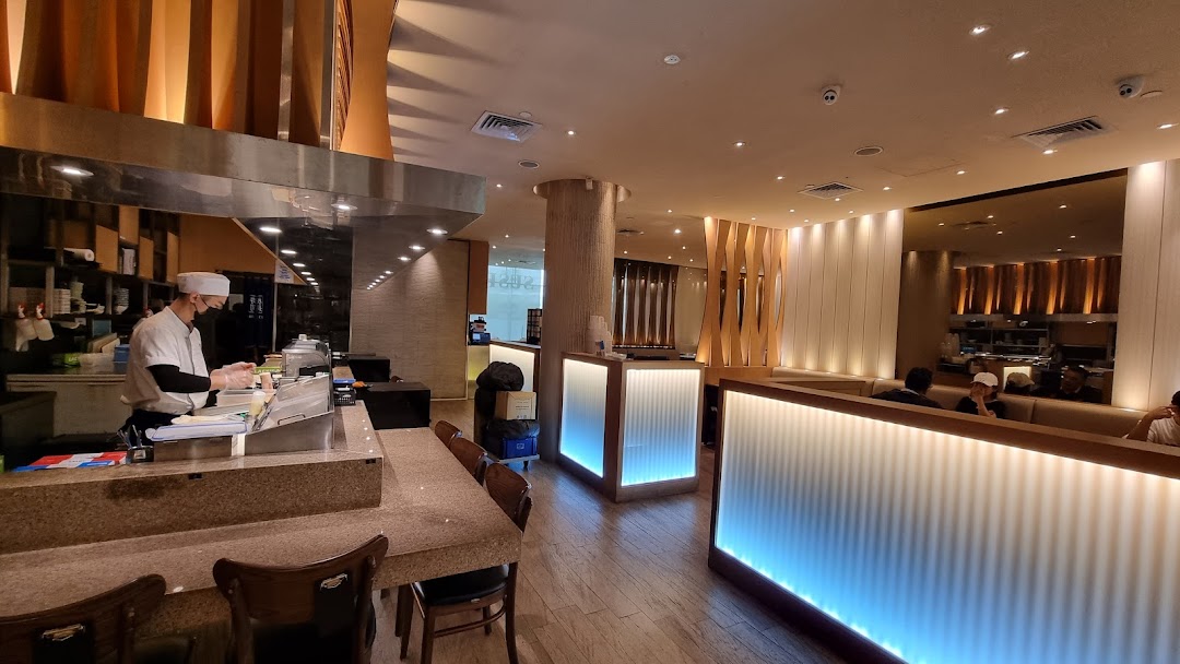 Interior view of Itacho Sushi, featuring a chef at the counter and modern dining area.