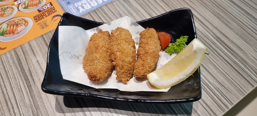 A plate of golden-fried items, possibly oysters or cutlets, served with a lemon wedge and garnish.