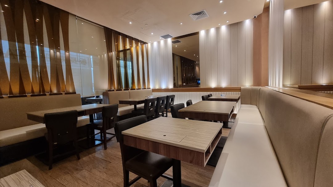 A spacious and modern dining area at Itacho Sushi with comfortable booth seating and tables.