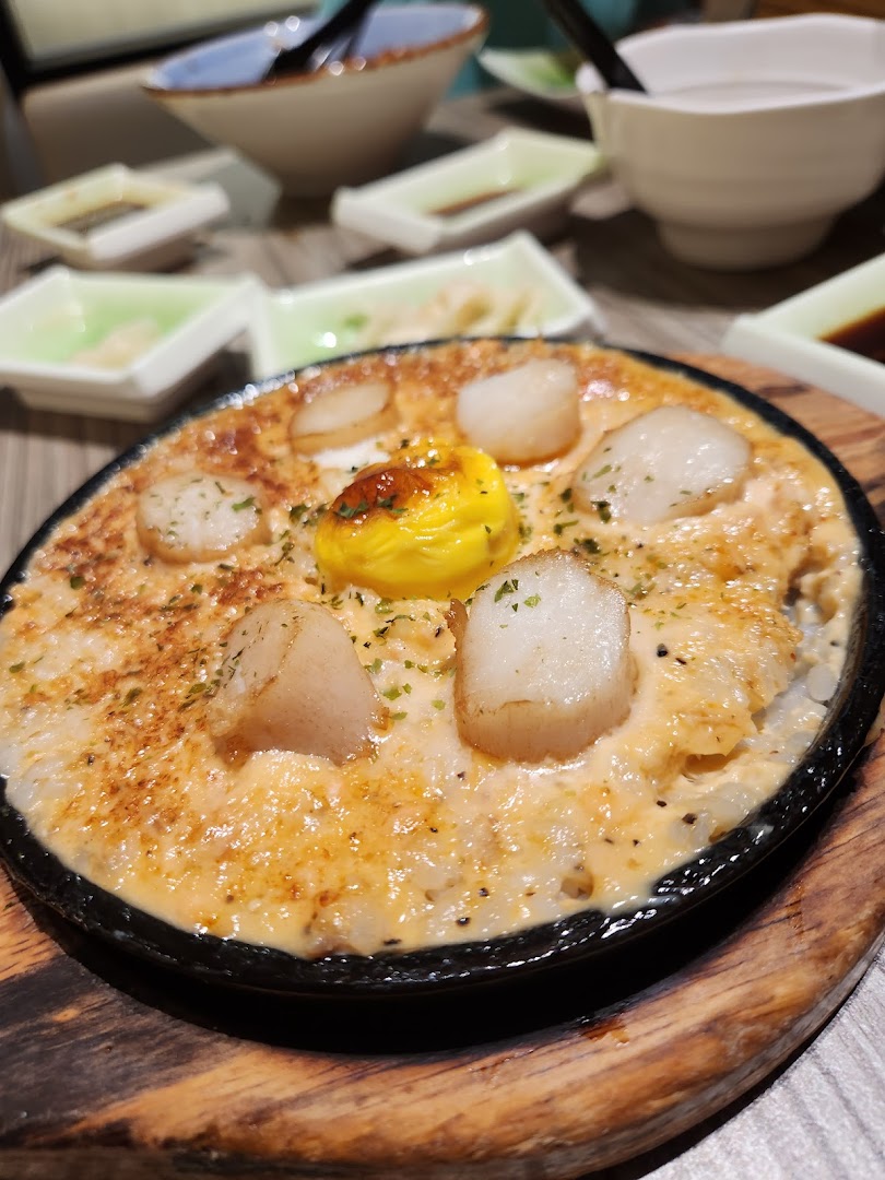 A sizzling hot plate dish featuring succulent scallops, creamy sauce, and a rich egg yolk at Itacho Sushi.