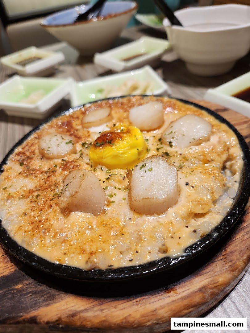 A sizzling hot plate dish featuring succulent scallops, creamy sauce, and a rich egg yolk at Itacho Sushi.