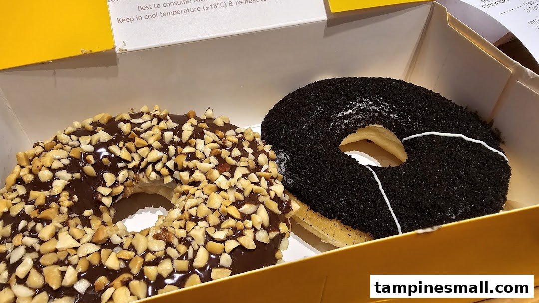 Two delicious donuts, one chocolate peanut and one dark chocolate, in a J.Co box.