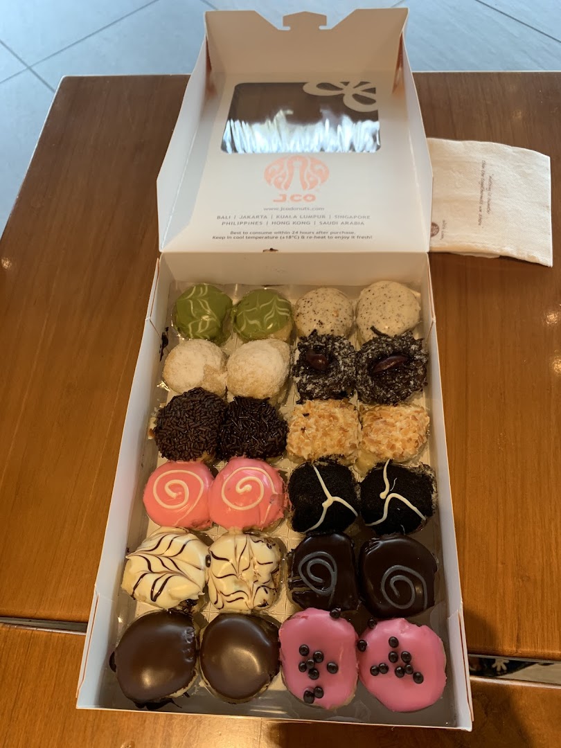 A box of colorful, assorted J.Co mini donuts with various toppings, ready to be enjoyed.