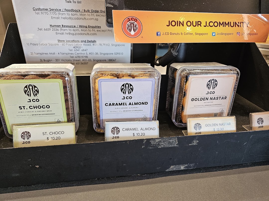 A display of J.Co's packaged cookies with prices and store information.