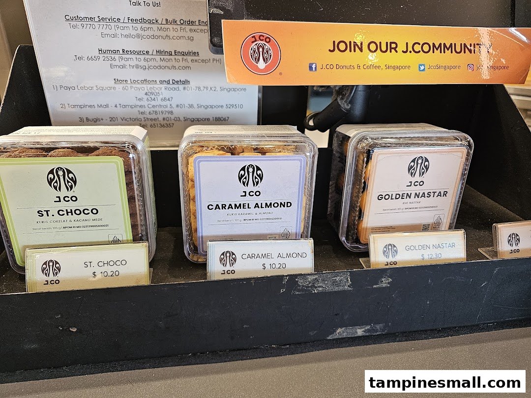 A display of J.Co's packaged cookies with prices and store information.