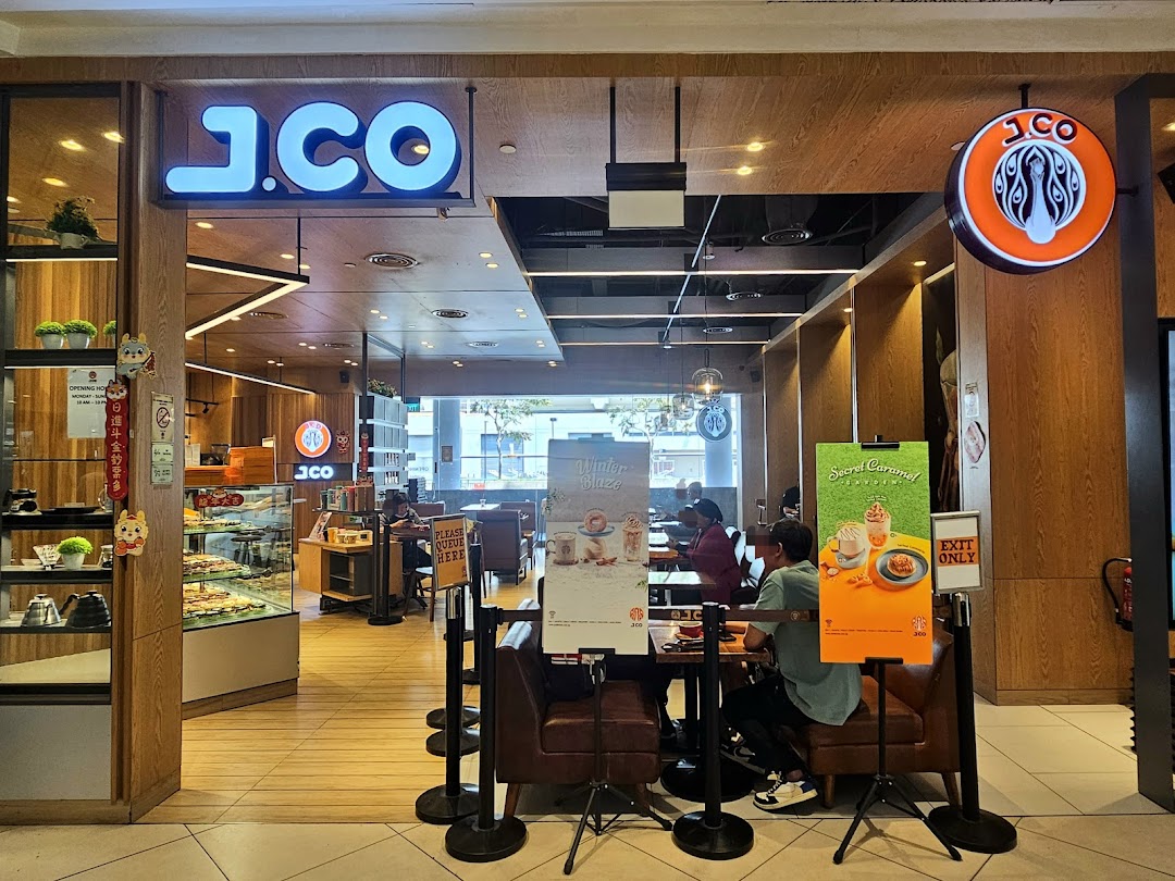 The inviting entrance of J.Co Donuts & Coffee, showcasing its interior and promotional displays.