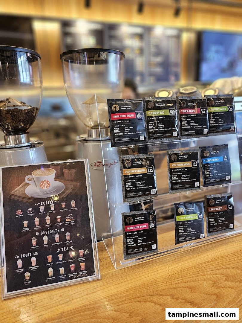A counter display at J.Co Donuts & Coffee featuring coffee beans, grinders, and a detailed beverage menu.