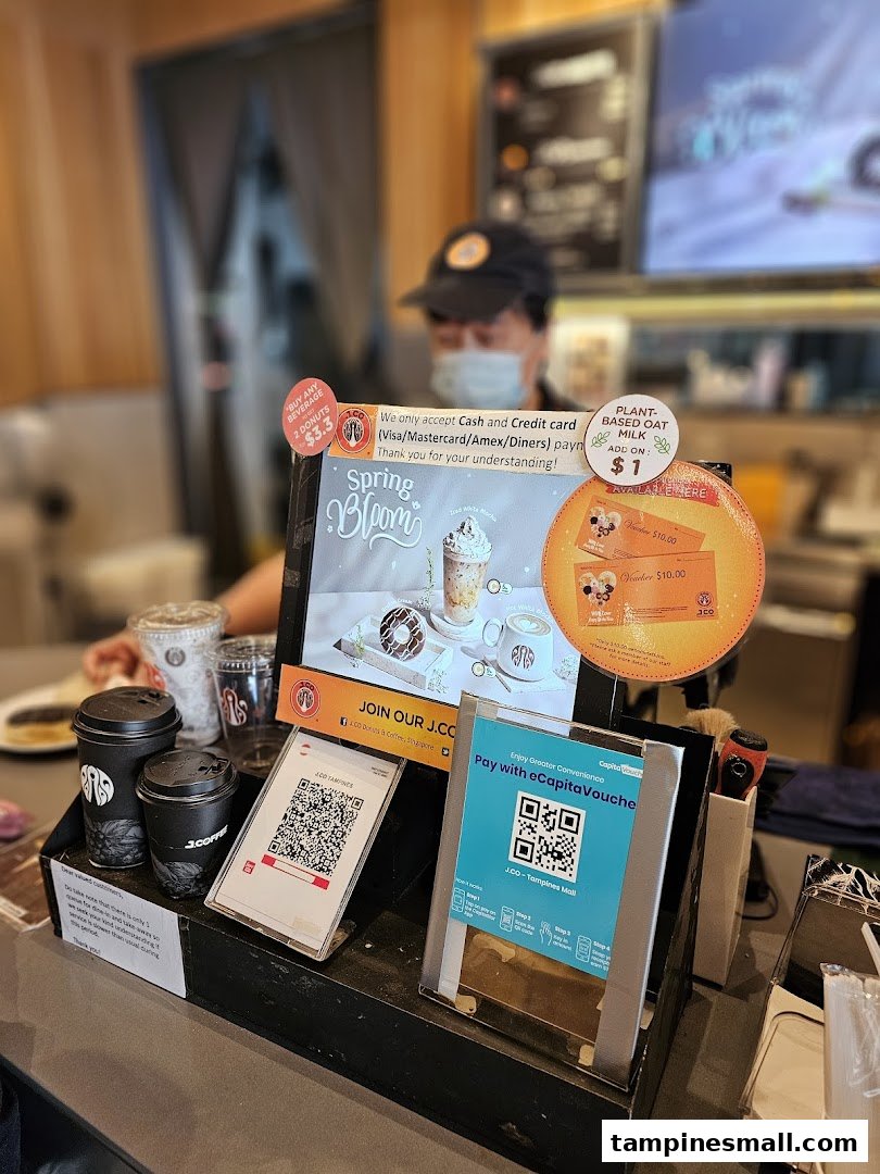 A close-up of the J.Co Donuts & Coffee counter showcasing current promotions and payment options.