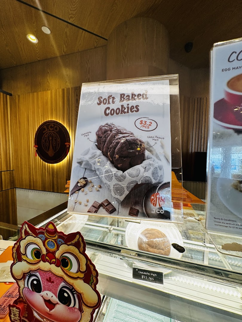 A close-up of a display stand showcasing J.Co's soft baked cookies with pricing.