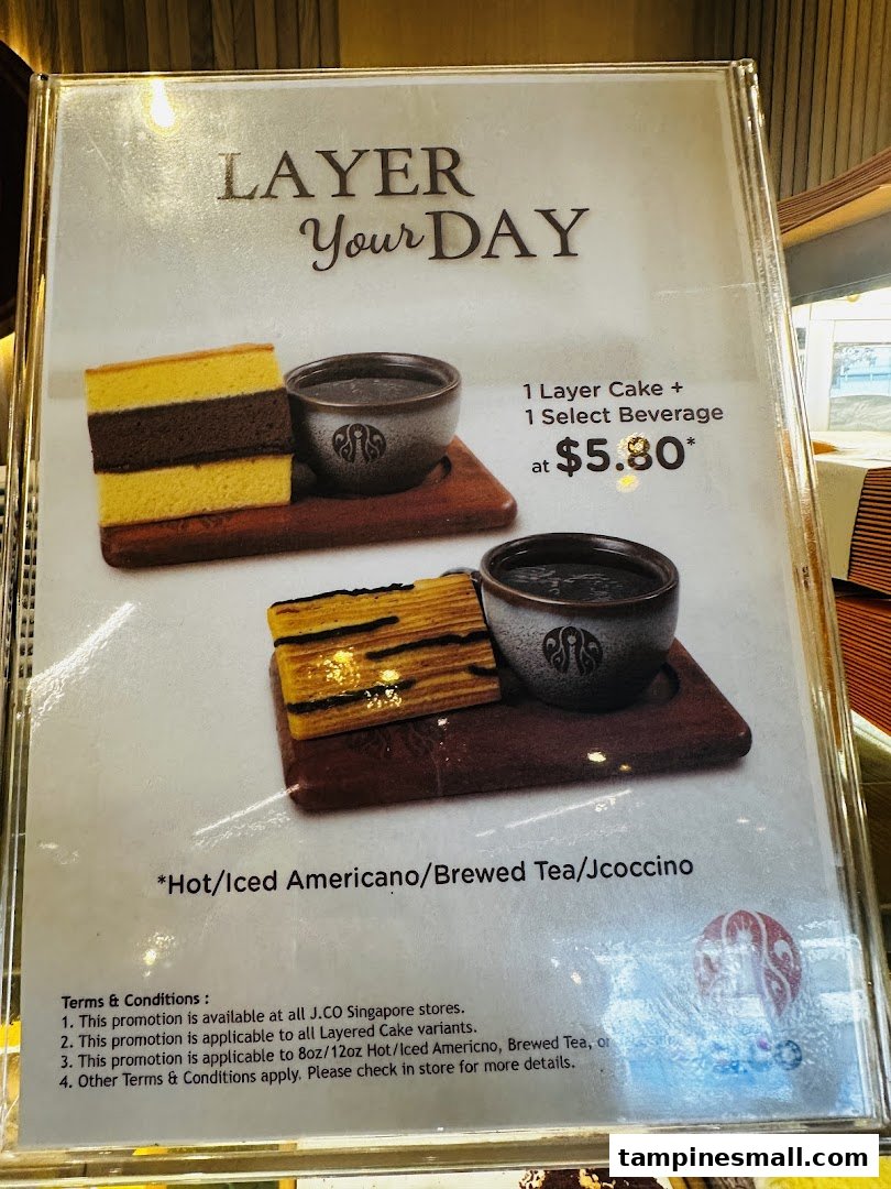 A promotional menu board displaying a 'Layer Your Day' offer with layered cake and beverage.