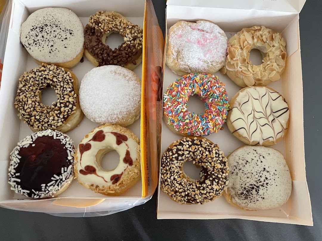 A vibrant assortment of J.Co Donuts in two boxes, showcasing various toppings and flavors.