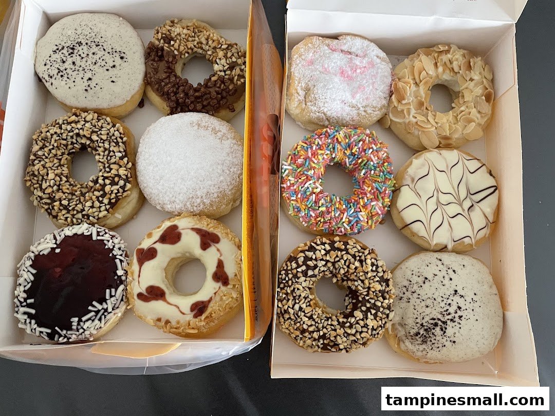 A vibrant assortment of J.Co Donuts in two boxes, showcasing various toppings and flavors.