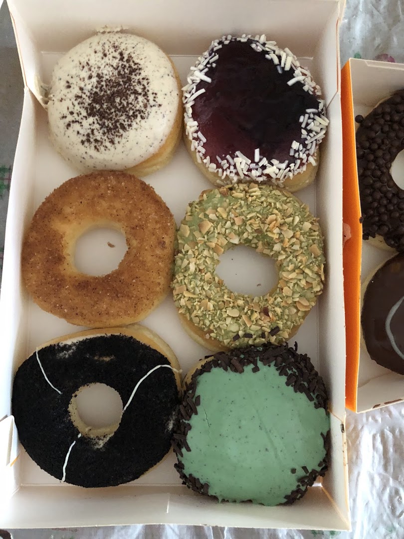 A box of assorted J.Co Donuts featuring various colorful glazes and toppings.
