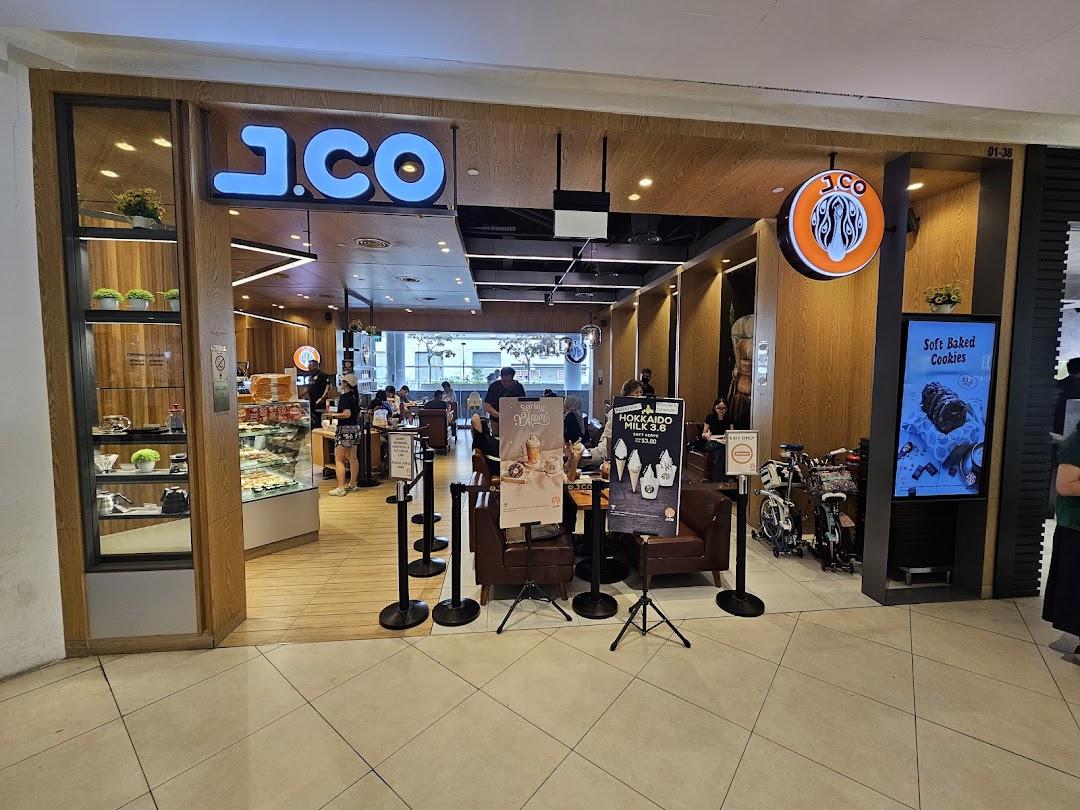 The inviting entrance of J.Co Donuts & Coffee, showcasing its modern interior and display of treats.