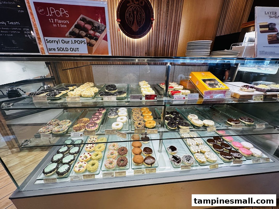 A vibrant display case showcasing a wide variety of colorful donuts and pastries at J.Co Donuts.