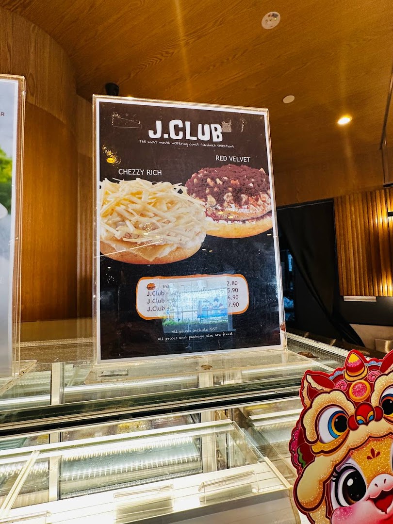 A menu board showcasing J.Co Donuts' J.Club donut sandwiches, including Cheezy Rich and Red Velvet.