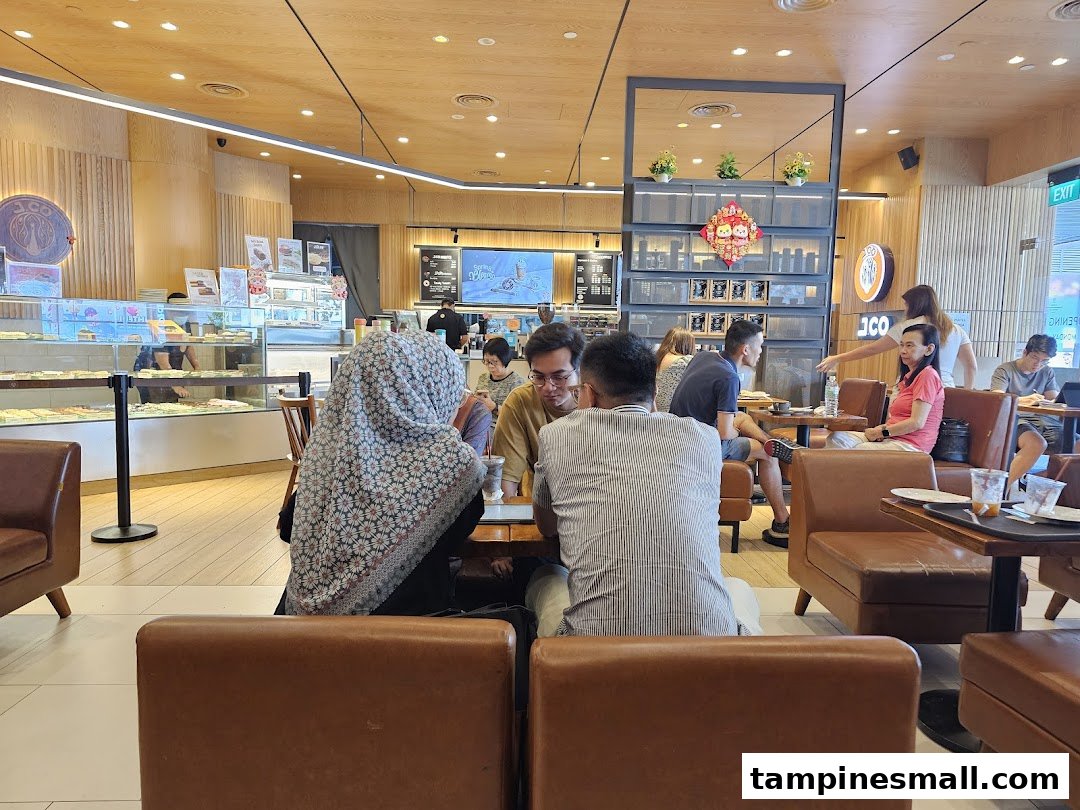 Customers enjoying fresh donuts and coffee in the modern, inviting interior of J.Co Donuts & Coffee.