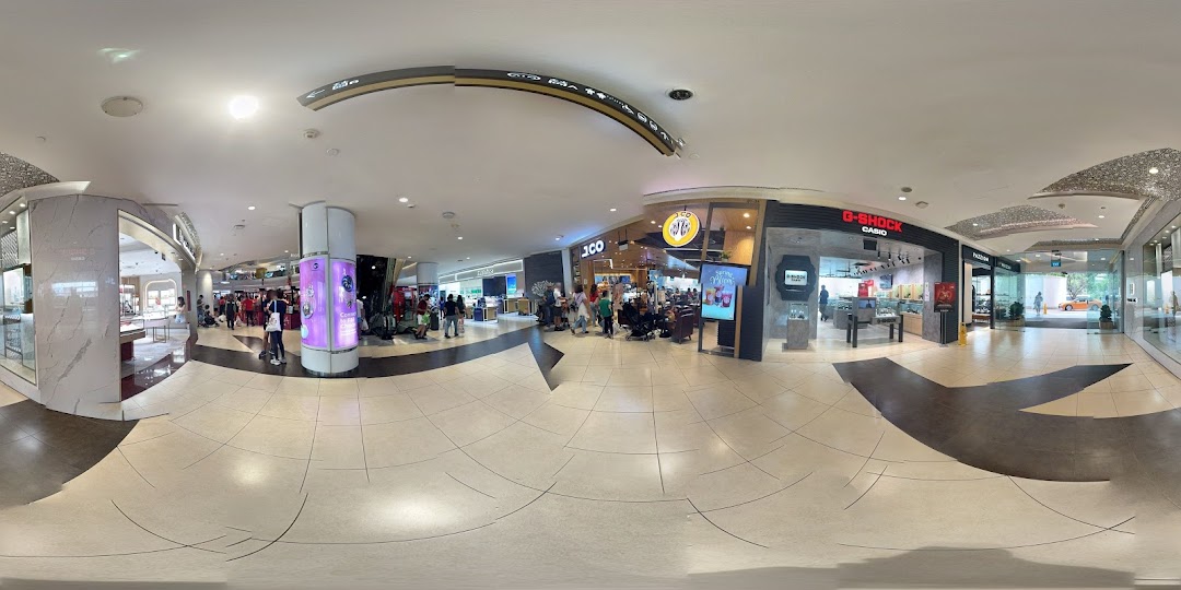 The bustling storefront of J.Co Donuts & Coffee, with customers queuing, located within Tampines Mall.