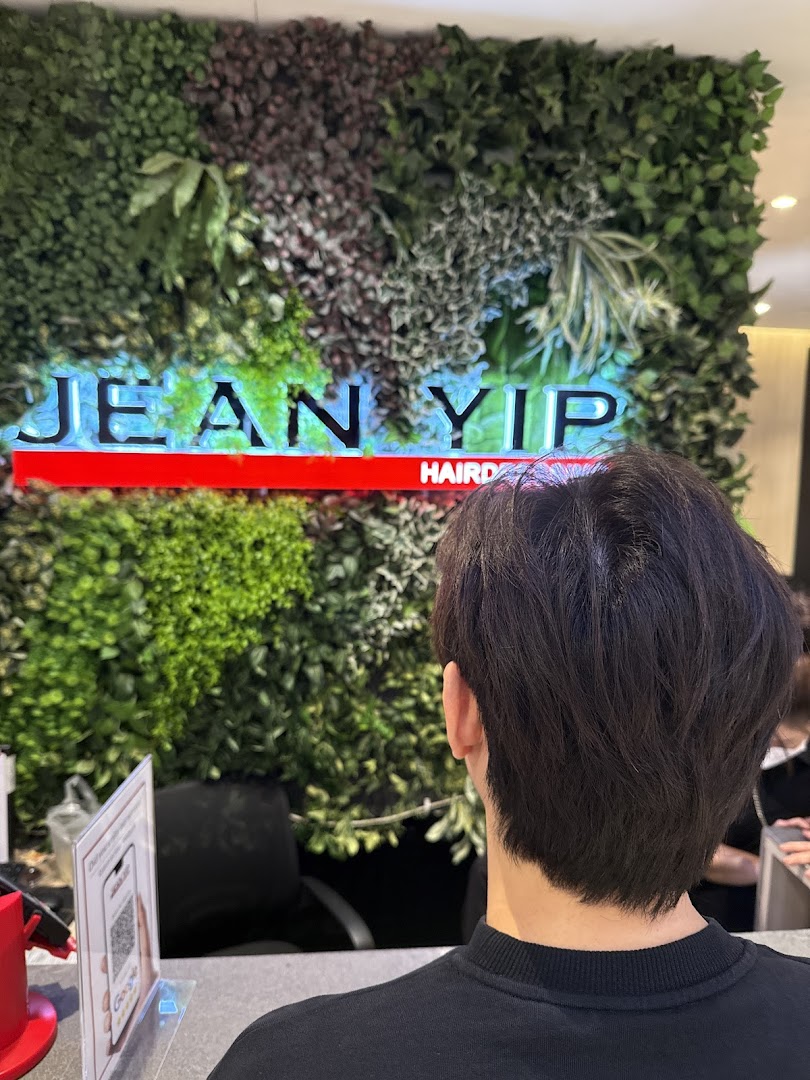 Interior view of Jean Yip Hairdressing and Beauty, featuring a green wall with the shop's illuminated logo.