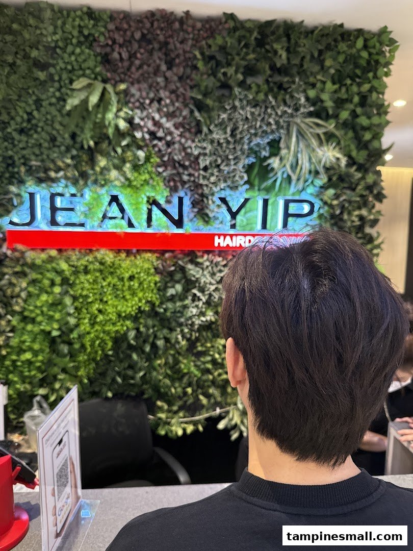 Interior view of Jean Yip Hairdressing and Beauty, featuring a green wall with the shop's illuminated logo.