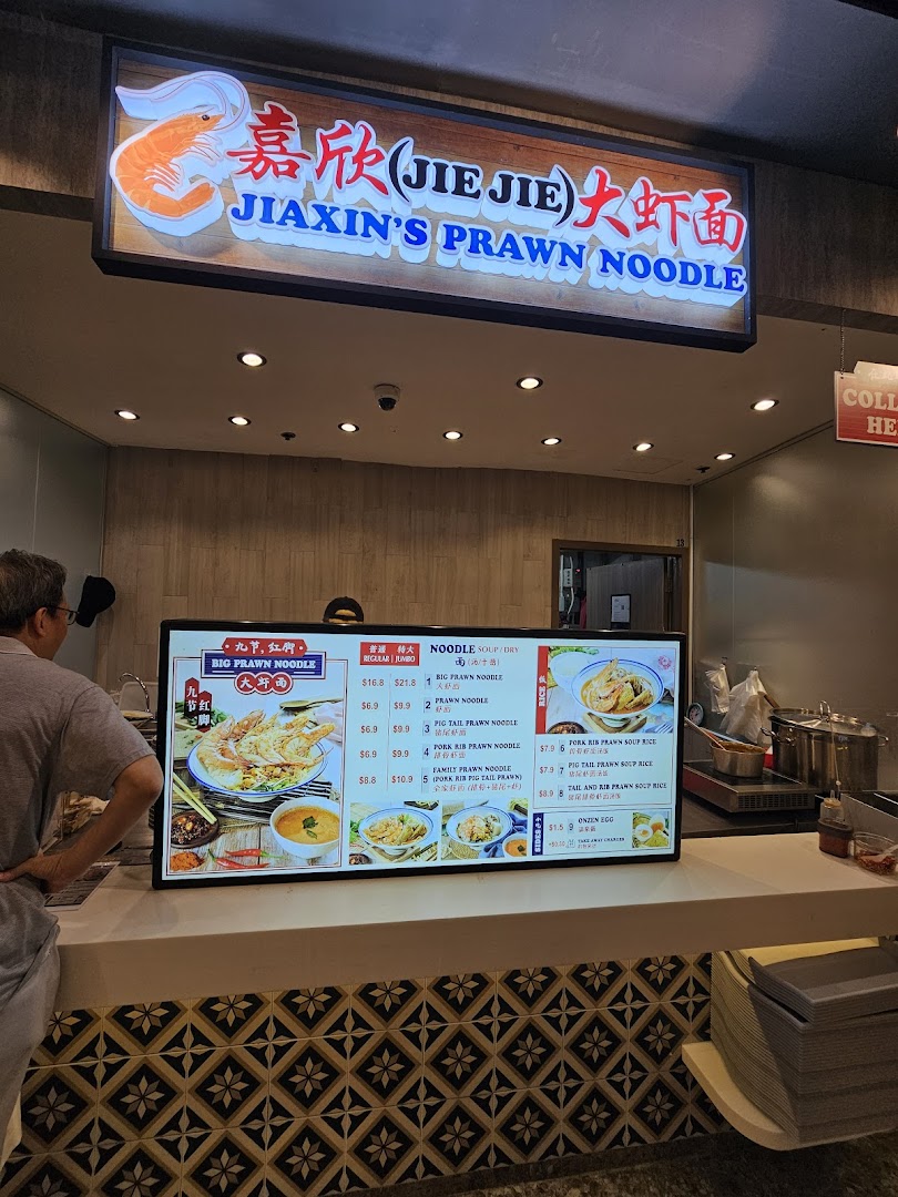A customer views the digital menu board at Jiaxin's Prawn Noodle stall.