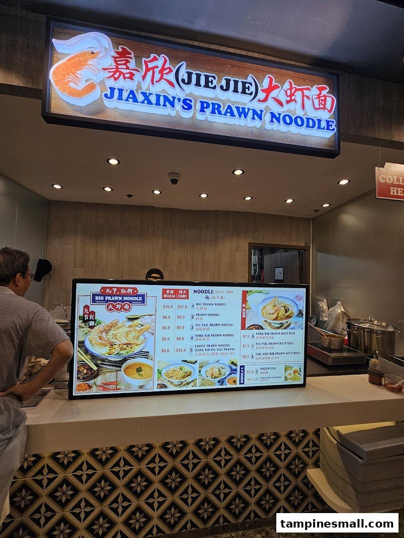 A customer views the digital menu board at Jiaxin's Prawn Noodle stall.