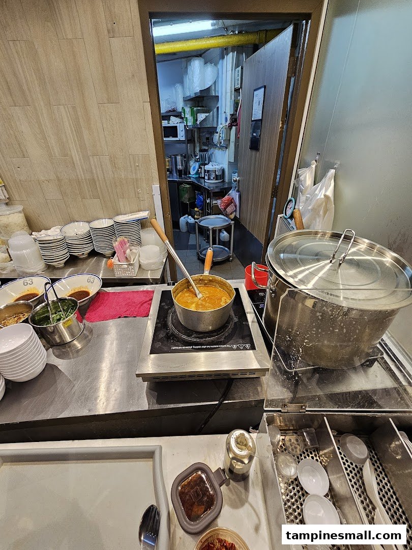 A bustling kitchen counter at Jiaxins Prawn Noodle, showcasing fresh ingredients and cooking in progress.