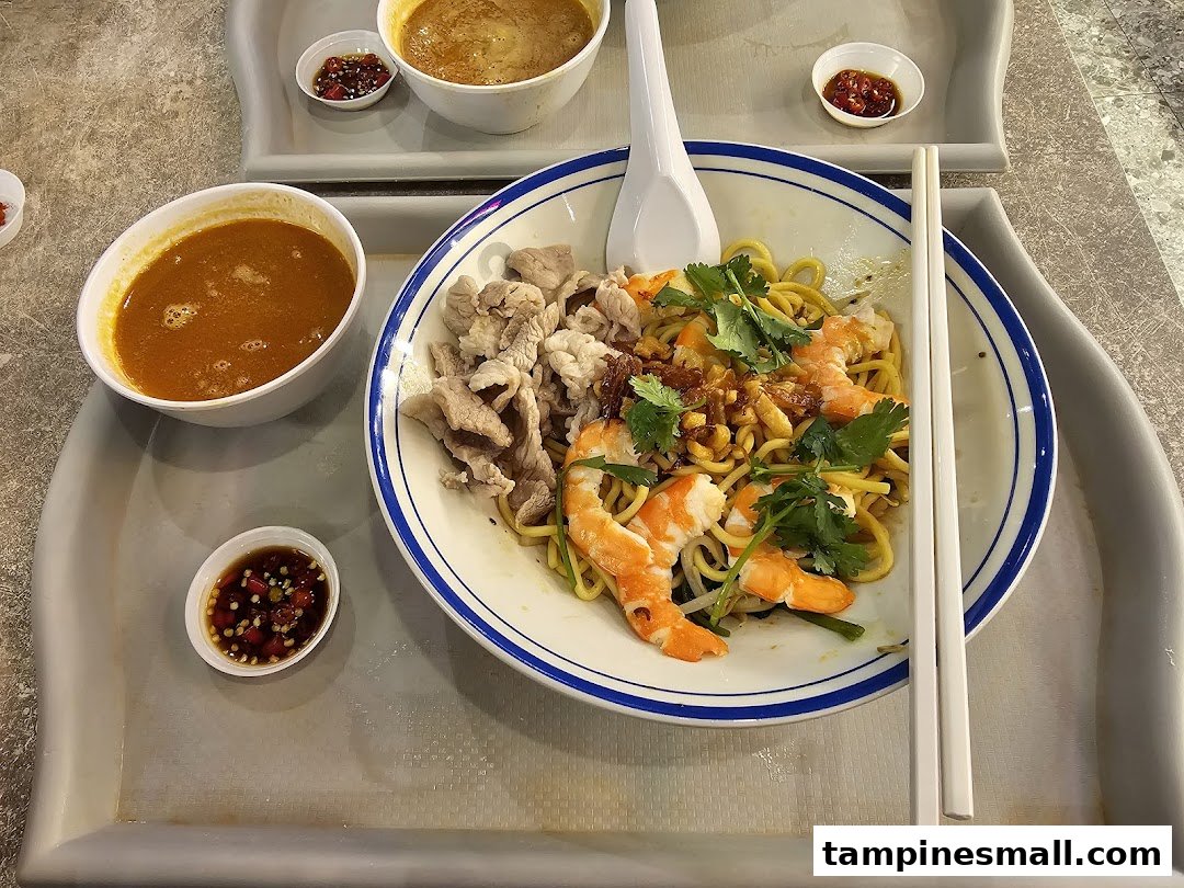 A delicious bowl of prawn noodles with soup, shrimp, and pork slices on a tray.