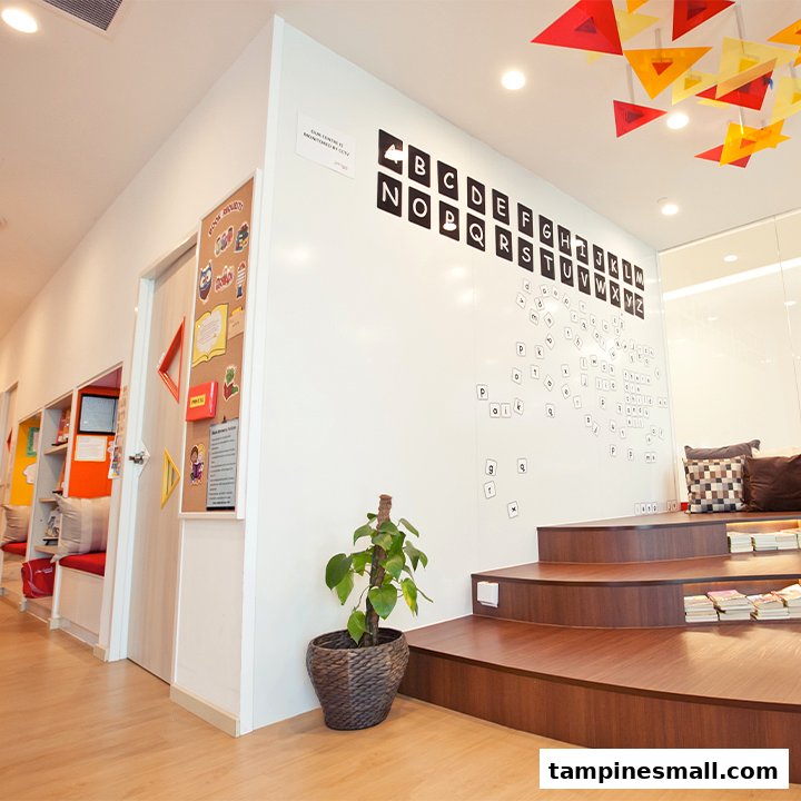 A bright, modern interior of a learning centre featuring an alphabet wall, tiered seating, and a cozy reading nook.