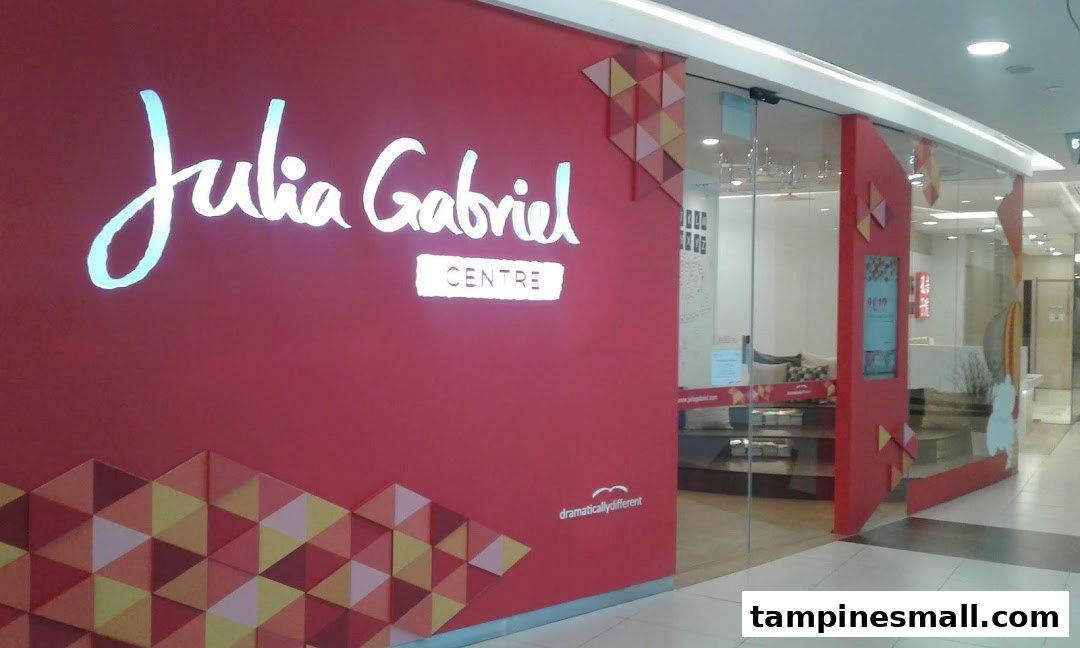 The bright red storefront of Julia Gabriel Centre with its illuminated logo and glass entrance.