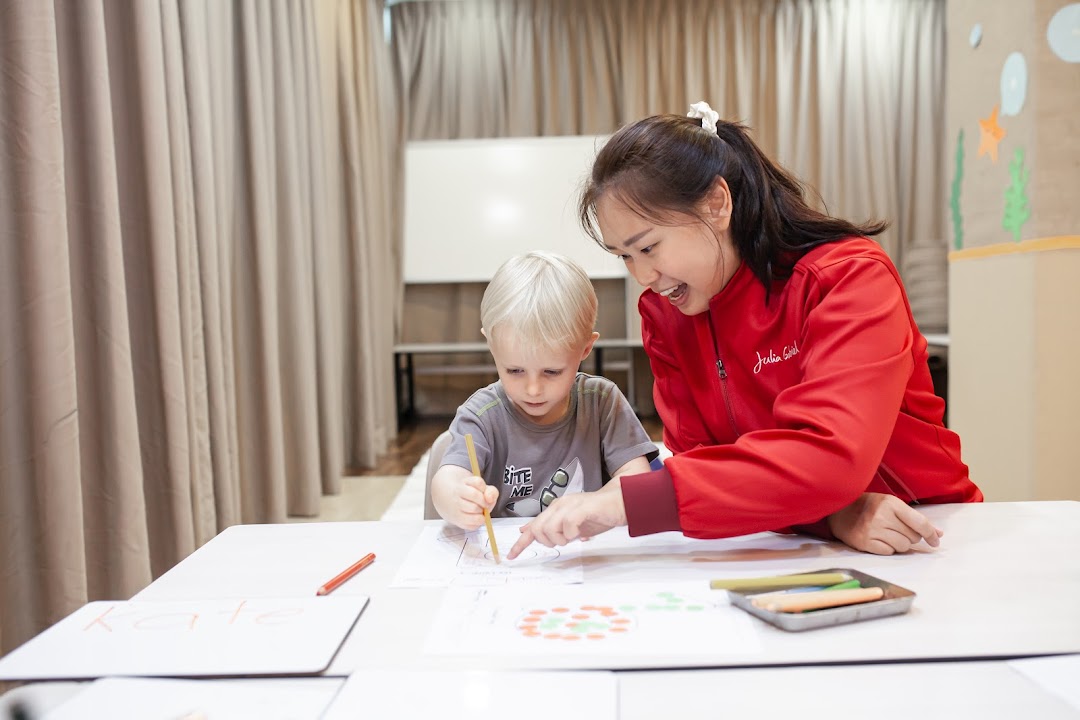 An instructor and a child engaged in a creative learning activity at Julia Gabriel Centre.