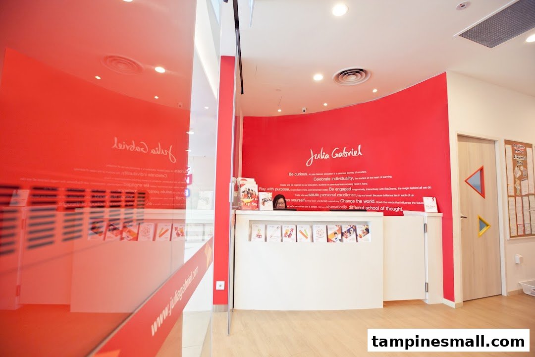 Interior view of Julia Gabriel Centre's vibrant reception area with a counter and red wall branding.
