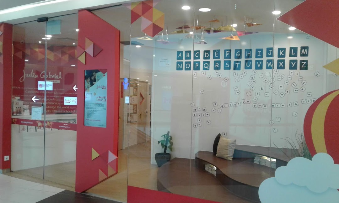 The vibrant storefront of Julia Gabriel Centre, an education facility, featuring colorful decor and alphabet displays.