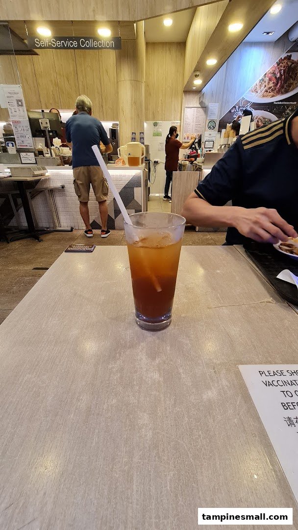 Interior view of Kaffe & Toast, featuring a drink on a table and customers at the counter.