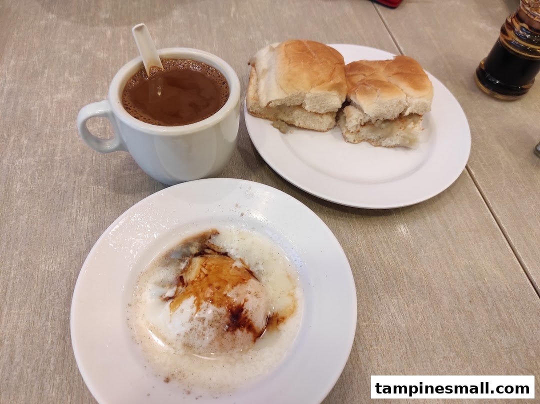 A traditional Singaporean breakfast set with coffee, soft buns, and a soft-boiled egg.