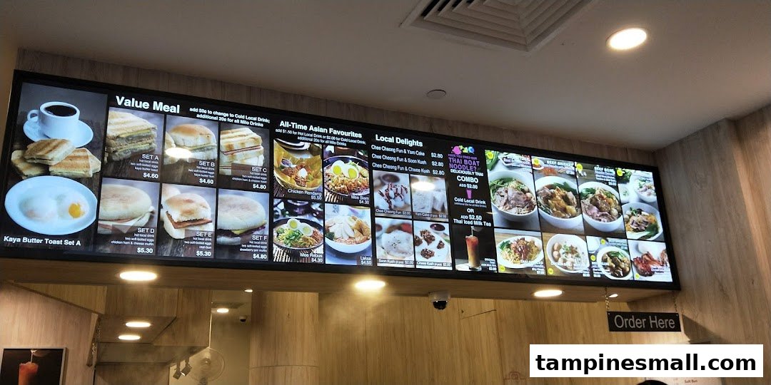 A digital menu board displaying various breakfast sets, Asian favorites, and local delights.