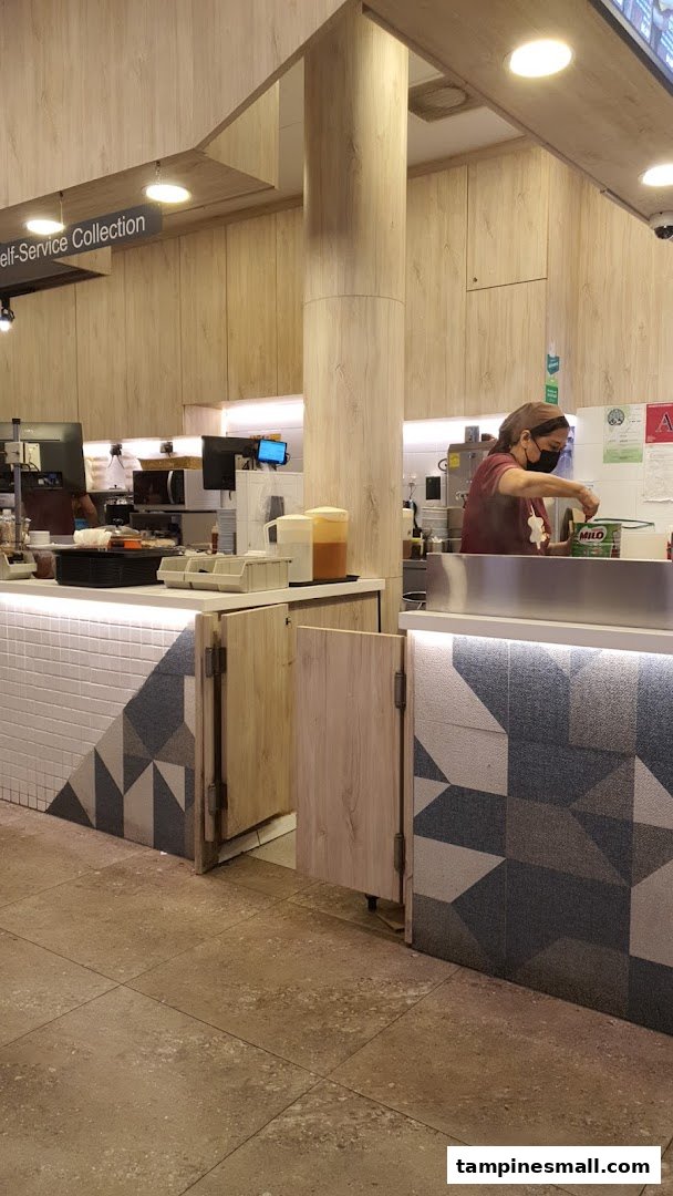A staff member prepares drinks behind the counter at Kaffe Toast Tampines Ctrl 5.