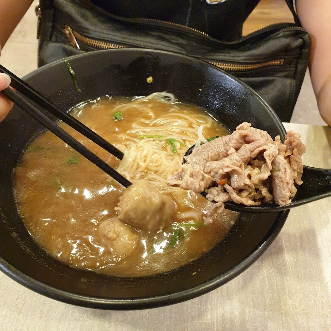 A close-up of a delicious bowl of beef noodles with meatballs, ready to be enjoyed.