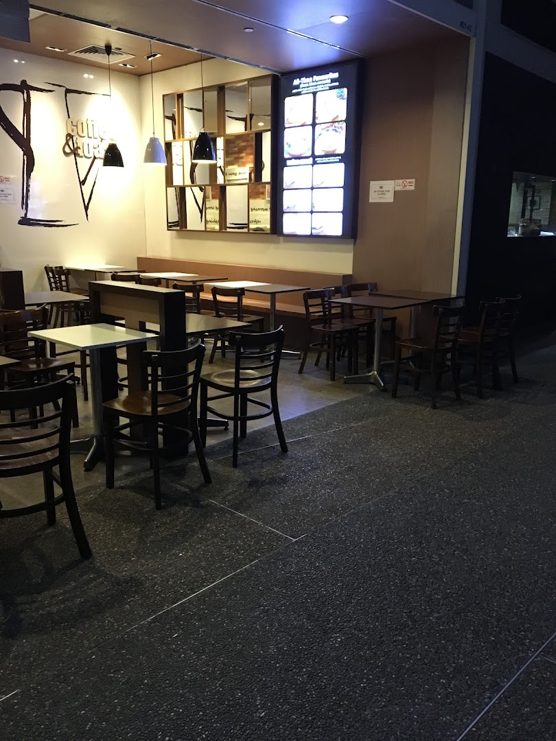 Interior view of Kaffe Toast cafe with various seating arrangements and an illuminated menu board.