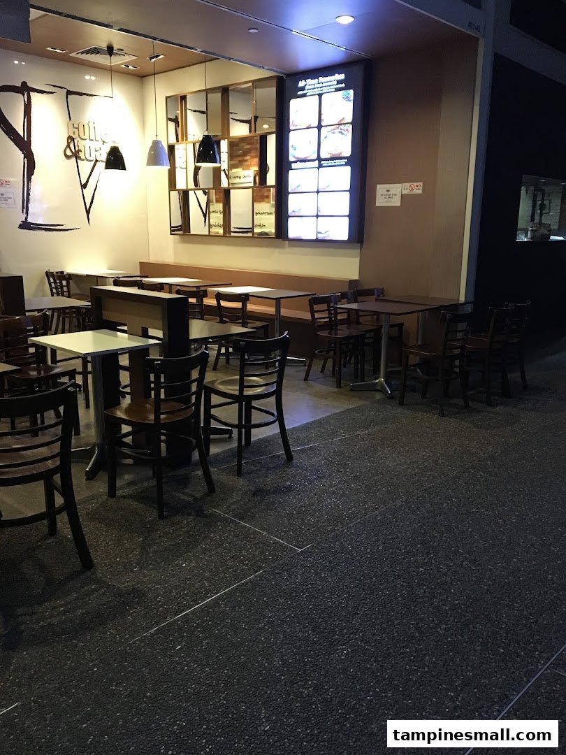 Interior view of Kaffe Toast cafe with various seating arrangements and an illuminated menu board.