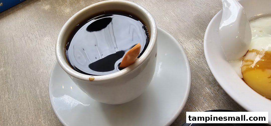 A close-up of a hot black coffee and soft-boiled eggs on a wooden table.