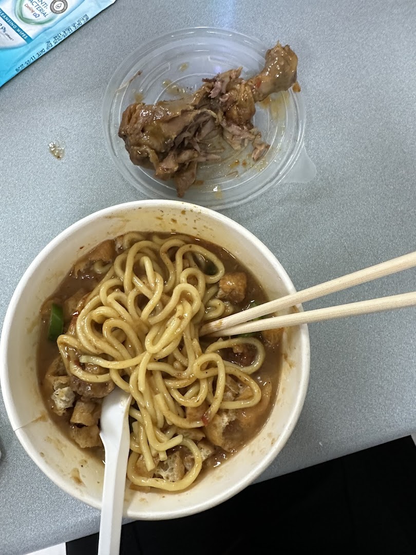 A comforting bowl of noodles with a side of braised chicken, showcasing a satisfying meal.