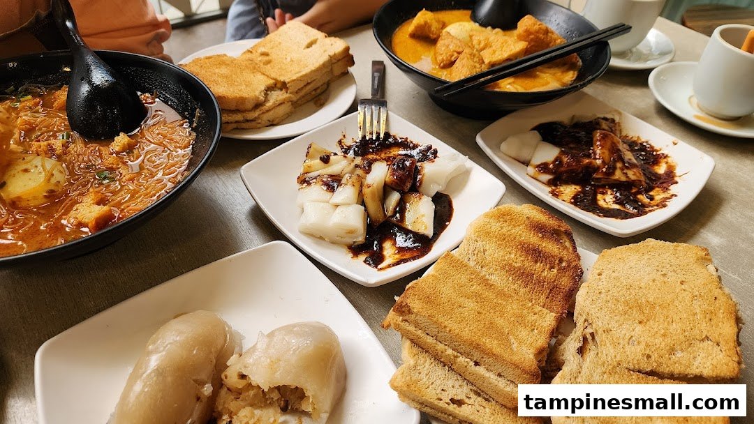 A table filled with various local dishes, including noodles, toast, and rice rolls.