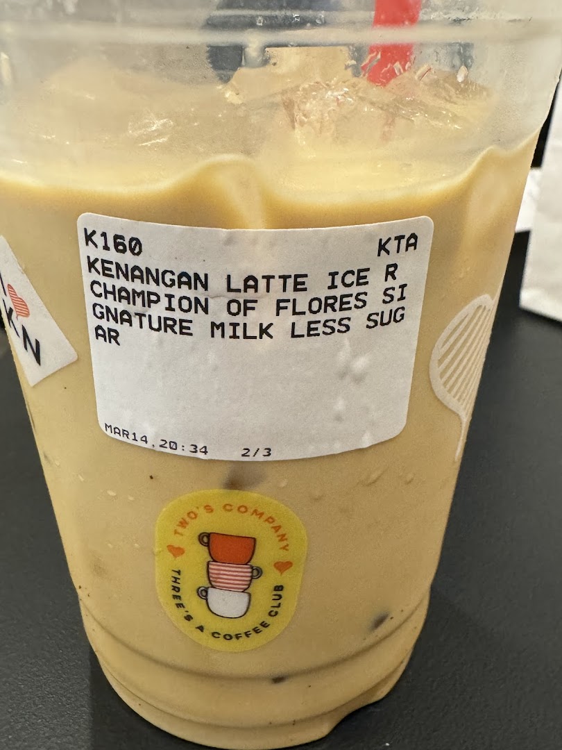 Close-up of an iced Kenangan Latte with a product label detailing its ingredients.
