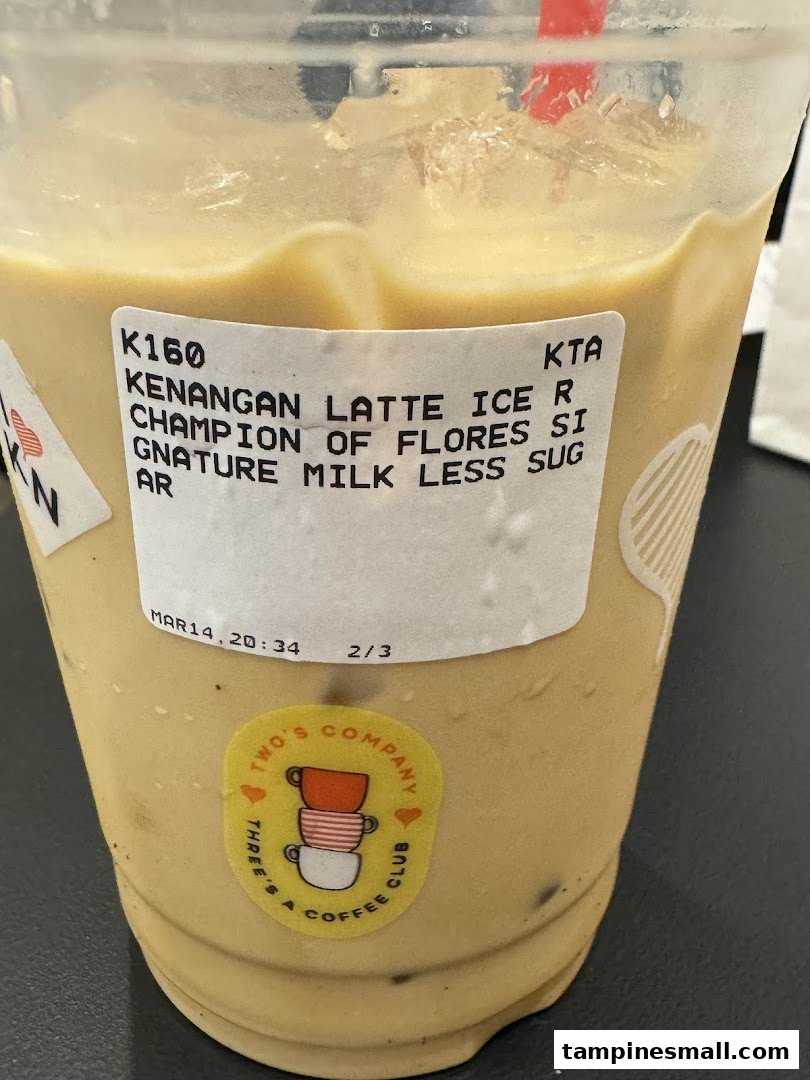 Close-up of an iced Kenangan Latte with a product label detailing its ingredients.